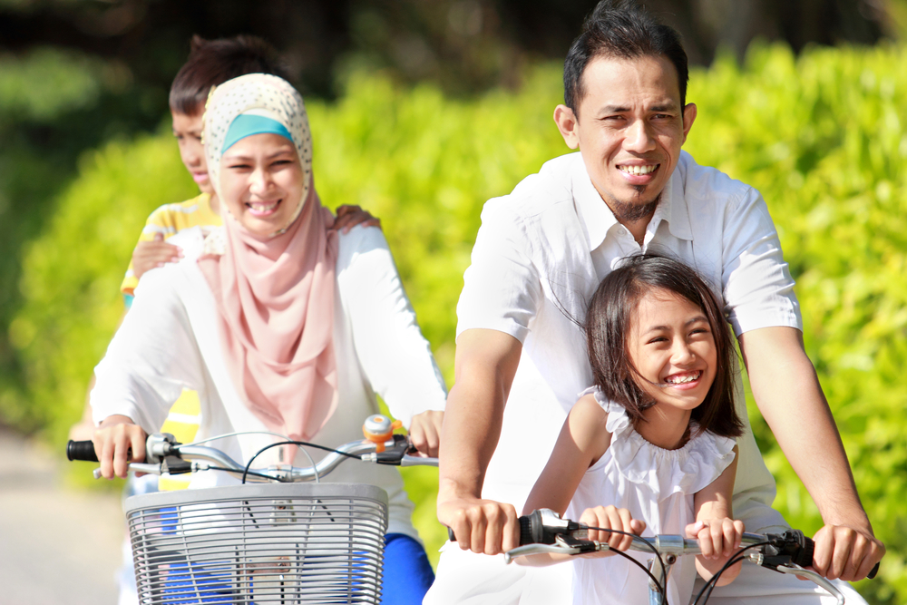 Keluarga Bersepeda Bersama di Pagi Hari