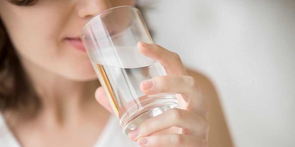Wanita Minum Segelas Air untuk Memulai Rutinitas Pagi